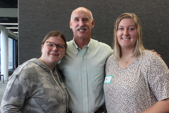  Jordan Burley '23, Steve Stork, and Elisa Swinehart '22 posing standing next to each other smiling